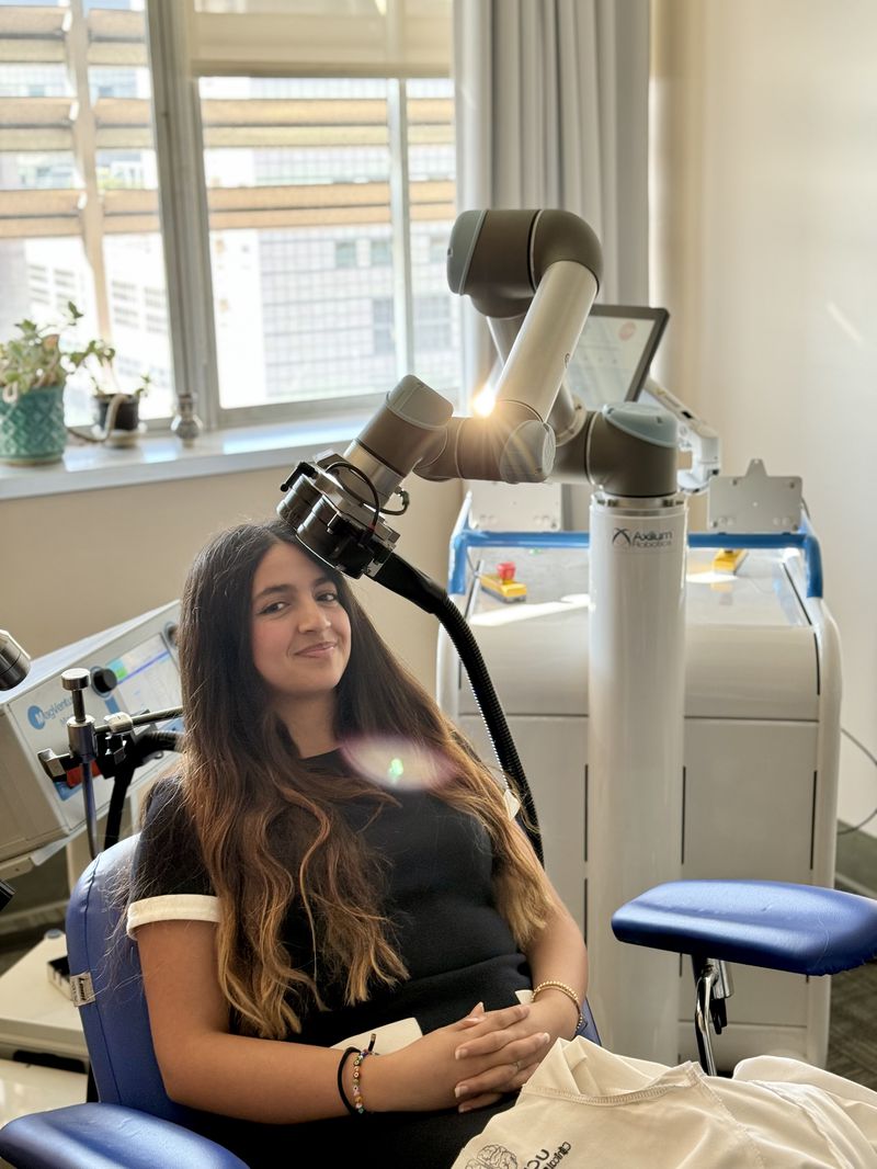A patient receiving robotic TMS treatment for chronic pain at UCLA